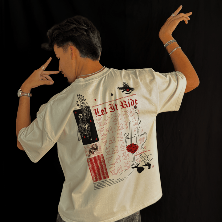 Man wearing the Let It Ride oversized tee in bone, seen from the back with one arm raised